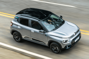 Citroën C3 em movimento em uma estrada, com paisagem ao fundo e design moderno em destaque.