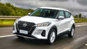 Nissan Kicks branco em movimento na estrada, com destaque para o design moderno e a carroceria em contraste com a paisagem ao fundo.