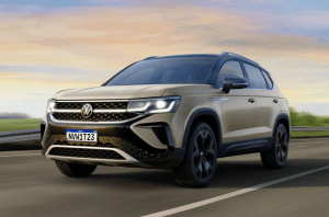 carro Volkswagen Taos cinza em movimento na estrada, destaque para o design robusto e moderno do SUV.