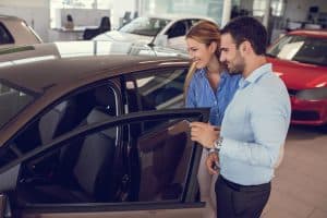young-couple-at-car-dealership-looking-at-new-car-together-4