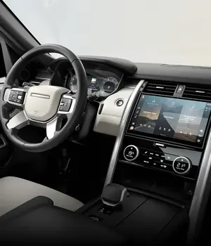 Painel interior de um carro, em cores preta e branco creme.